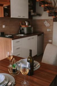 a bottle of wine sitting on a table with two glasses at Matino Apartment 1 in Valjevo