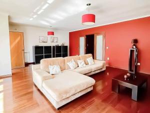 een woonkamer met een bank en een tv bij Be in Paradise Villa in Esposende