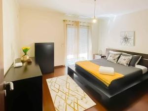 een slaapkamer met een groot bed met een gele deken bij Be in Paradise Villa in Esposende