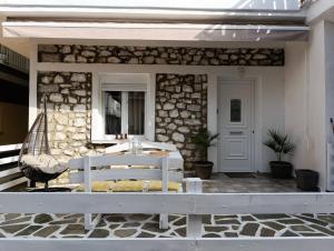 a porch with a white bench and a stone wall at La bella casa thassos in Limenas