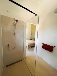 a bathroom with a shower and a bedroom at Dushi Shelter studio in Willemstad