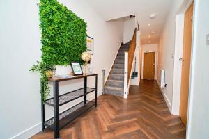 a hallway with a staircase and a green wall at Hello Stays in Stafford