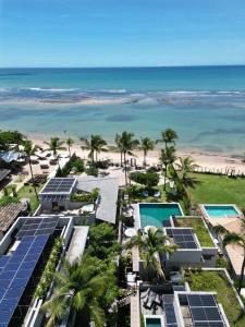 阿拉亚尔达茹达Santa Aldeia Hotel的享有度假胜地的空中景致,设有太阳能电池板和海滩