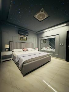 a bedroom with a large bed with a star ceiling at Relax Under the Stars 1BHK in Lahore