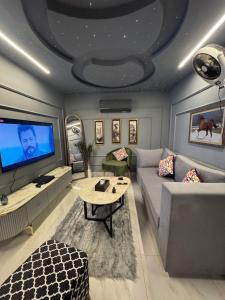 a living room with a couch and a tv at Relax Under the Stars 1BHK in Lahore