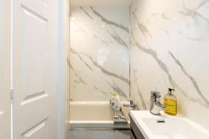 a white bathroom with a sink and a mirror at Luxury Studio with Free Parking in Nottingham +6 photos