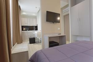 a bedroom with a bed and a television on a wall at Hotel Agrigento Home in Agrigento