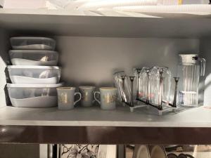 a shelf with cups and plates and other dishes at Relax Under the Stars 1BHK in Lahore