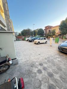 a man walking in a parking lot with cars at Relax Under the Stars 1BHK in Lahore