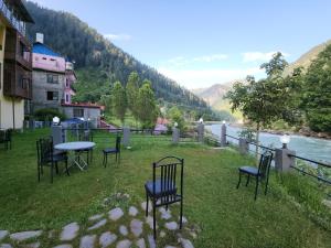 a group of chairs sitting around a table in the grass at Bono Apartments in Nārān +14 photos