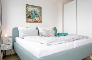 a large bed in a room with a painting on the wall at Alte Druckerei Cicero in Norderney