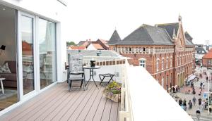 a balcony with a table and chairs on a building at Alte Druckerei Cicero in Norderney