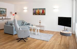 a living room with a couch and a chair and a television at Alte Druckerei "Bodoni" in Norderney