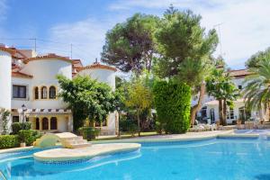 a large swimming pool in front of a house at Adosado La racona, Las Rotas de Denia in Denia