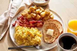a plate of breakfast food with eggs bacon and toast at Sheraton Miami Airport Hotel and Executive Meeting Center in Miami