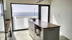 a kitchen with a counter and a large window at Roque Ocean House - Atlantic Serenity Escape in São Roque