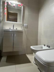 a white bathroom with a toilet and a sink at OH! Bahia Depto con cochera FREE in Bahía Blanca +3 photos
