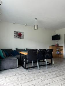 salon z kanapą, stołem i krzesłami w obiekcie Domek u Beaty w Kudowie Zdroju