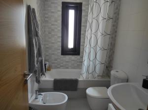 a bathroom with a sink and a toilet and a window at Apartamento Pelícanos in Fisterra