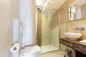 a bathroom with a shower and a toilet and a sink at Alison Apartments in Premantura