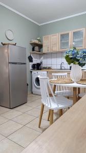 a kitchen with a table with chairs and a refrigerator at La bella casa thassos in Limenas