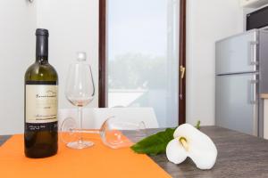 a bottle of wine and glasses on a table at Alison Apartments in Premantura