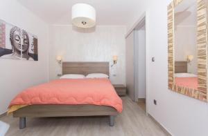 a bedroom with a bed and a large mirror at Alison Apartments in Premantura