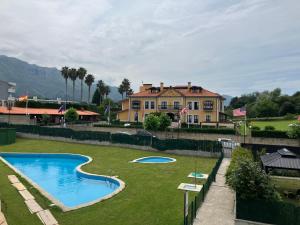 a yard with a swimming pool in front of a house at Apartamento Boutique Arquera Golf III in Llanes