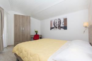 a bedroom with a bed and a painting on the wall at Alison Apartments in Premantura