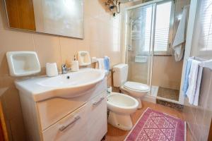 a bathroom with a sink and a toilet and a shower at Οικια in Avola