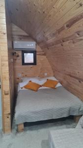 アヴリグにあるCăsuțe în mijlocul naturii - Wild Camp Avrigの木造キャビン内のベッド1台が備わるベッドルーム1室を利用します。