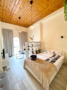 a bedroom with a large bed with a wooden ceiling at Cozy Suite near the ParisSquare in Haifa
