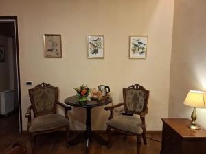 una habitación con 2 sillas y una mesa con flores en Residence Castelului, en Brasov