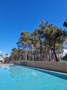 a swimming pool with a fence and trees in the background at Desconectaengalicia Rincón de Cabodeiro in Isla de Arosa
