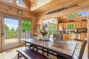 a dining room with a wooden table and a kitchen at Tatanka at LakeLure Rumbling Bald Hot Tub Fire Pit in Lake Lure