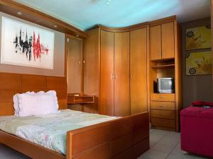 インベーにあるCasarão Espaçoso com Piscina e Churrasqueira Perfeito para Família e Amigosのベッドルーム(ベッド1台、キャビネット、テレビ付) +188枚の写真