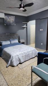 a bedroom with a bed and a blue wall at Nuria luxurious 2 bedroom apartments in Inchaban