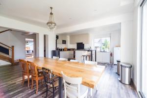 a kitchen and dining room with a wooden table and chairs at Maison 8 pers jardin centre ville 15 min de plages in Lannion