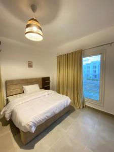 a bedroom with a bed and a large window at Luxurious 3BR Chalet Aqua Park View Amwaj in El Alamein