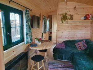 a room with a bed and a table in a cabin at Pipowagen Harambé in Lanaken