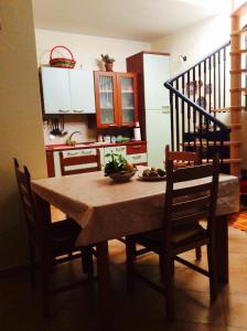 a dining room table with chairs and a kitchen at Cozy Apartment by the Sea in Acireale