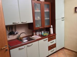 a small kitchen with white cabinets and a sink at Cozy Apartment by the Sea in Acireale