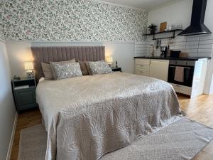 a bedroom with a large bed and a kitchen at Kvarnviks Gård Close to Sea & Charming Country Stay in Klagstorp