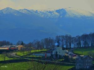 a building in a field with mountains in the background at Hotel Parrilla el Zangano in Boal