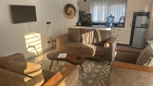 a living room with a couch and a chair and a table at Flic and Flac Apartments Apt 8 in Kampala