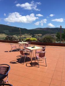 a group of tables and chairs on a patio at Hotel Parrilla el Zangano in Boal