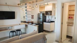 a kitchen with a couch and a kitchen with a refrigerator at FLATS - DUO JK in Sao Jose do Rio Preto