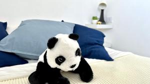 a stuffed panda bear sitting on a bed at Beautyful Resort Apartment in Haifa