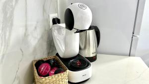 a coffee maker on a counter next to a basket of cookies at Beautyful Resort Apartment in Haifa