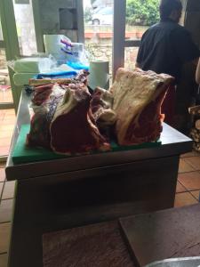 a table with a bunch of meat on a counter at Hotel Parrilla el Zangano in Boal